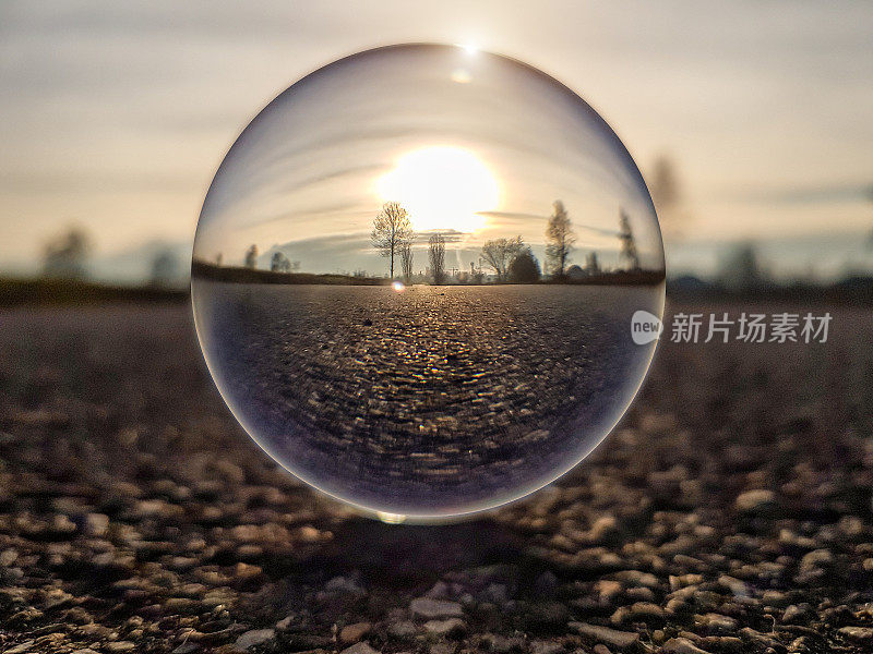 通过镜头球(水晶球)的乡村道路上的日落-意大利