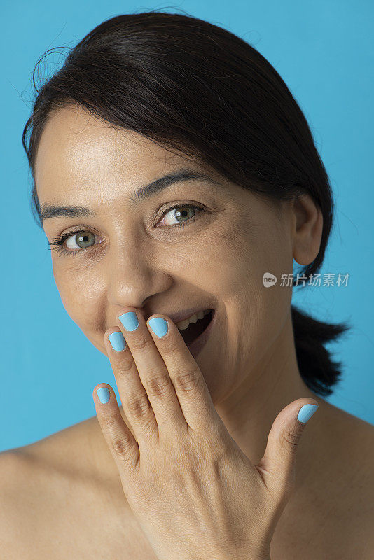 女人的手涂着蓝色指甲油
