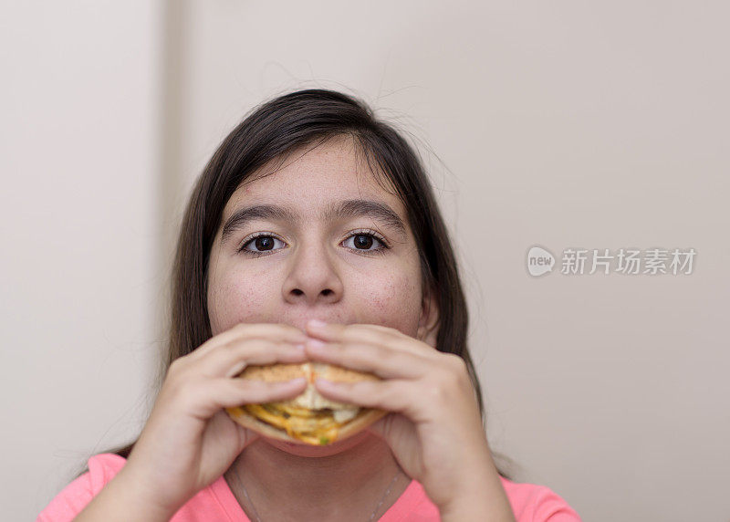 小女孩在室内吃汉堡