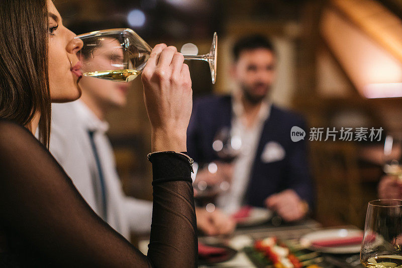 美女在午餐时喝白葡萄酒