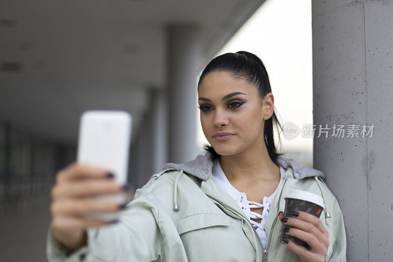 年轻迷人的女人用手机自拍