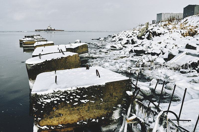 建筑混凝土块覆盖雪，沉船，海洋，岩石海岸，雪堆