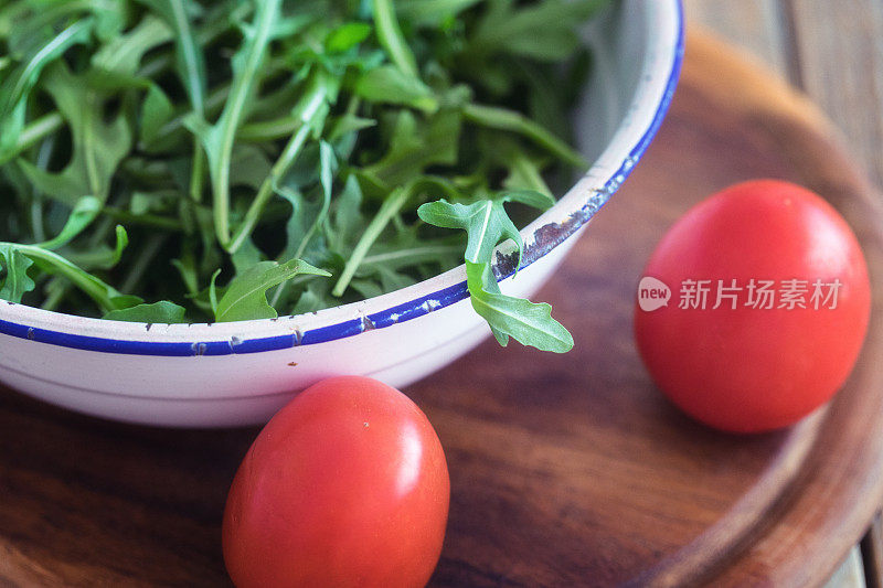 新鲜芝麻菜叶和西红柿一起放在锅里，特写