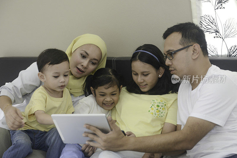 马来西亚家庭在家里一起使用平板电脑