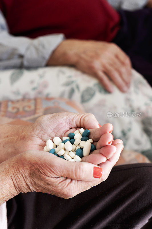 老女人手里拿着一堆药丸