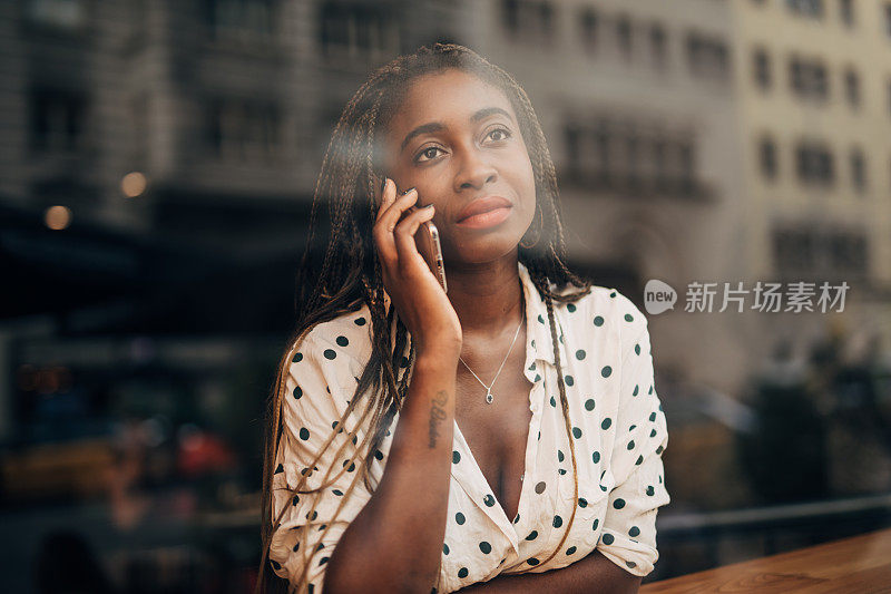 美丽的黑人女人在咖啡馆里打电话