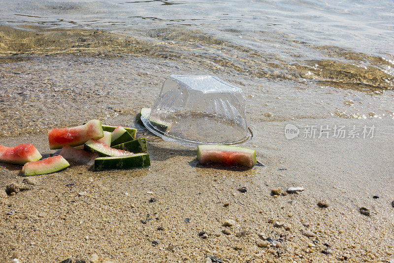 海滩污染。塑料碗和海滩上的其他垃圾