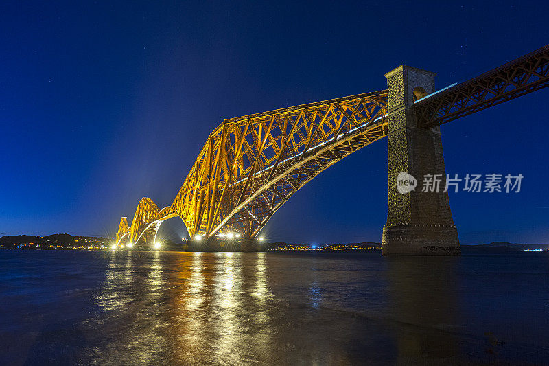 黄昏时照亮英国苏格兰爱丁堡的福斯湾铁路桥。