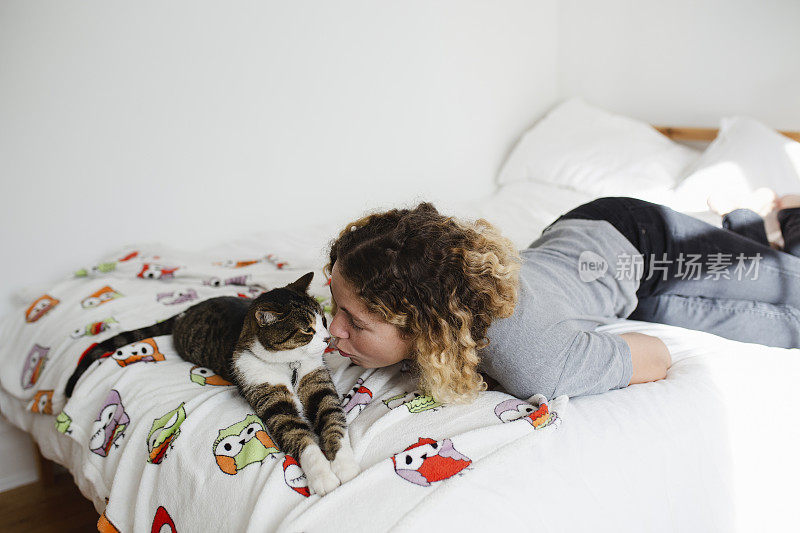 一个年轻女人和一只猫在床上