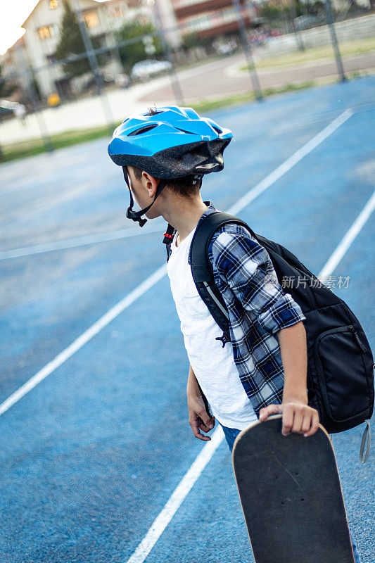 小学男孩在操场上玩滑板