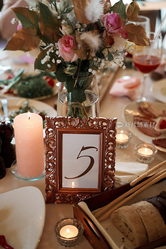 桌子上有食物，鲜花，蜡烛和桌子号码。