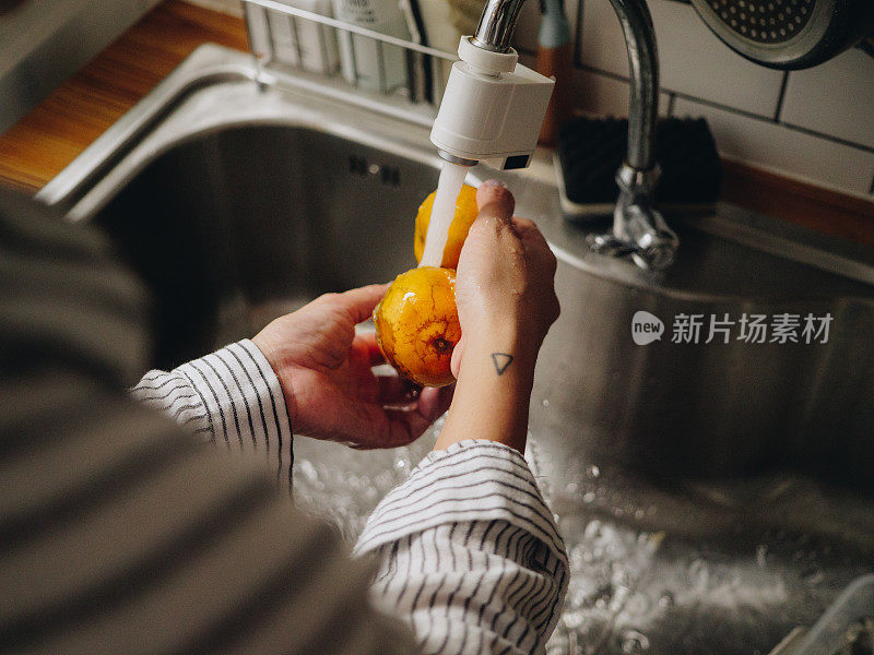 千禧一代亚洲妇女在早上做橙汁