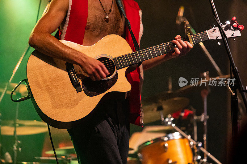 赤裸上身的男人在舞台上弹吉他
