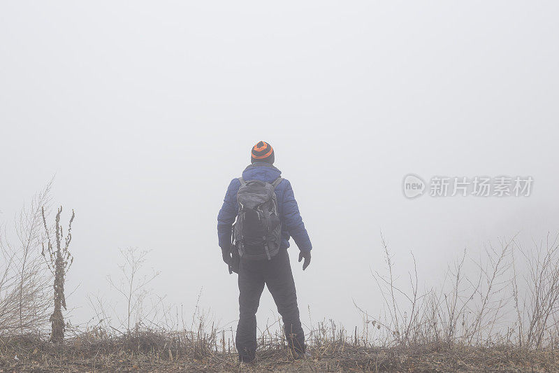 一名成年男子在寒冷多雾的日子徒步旅行