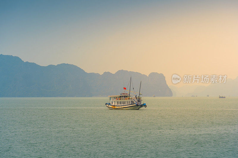 越南广宁省下龙湾景观;有很多石灰岩小岛和游轮;在一个蓝天的夏日