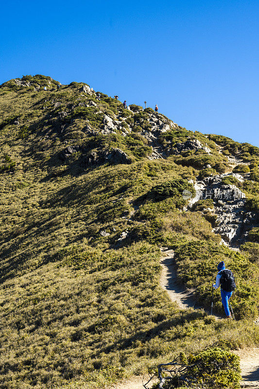 徒步旅行者独自走在山顶上。