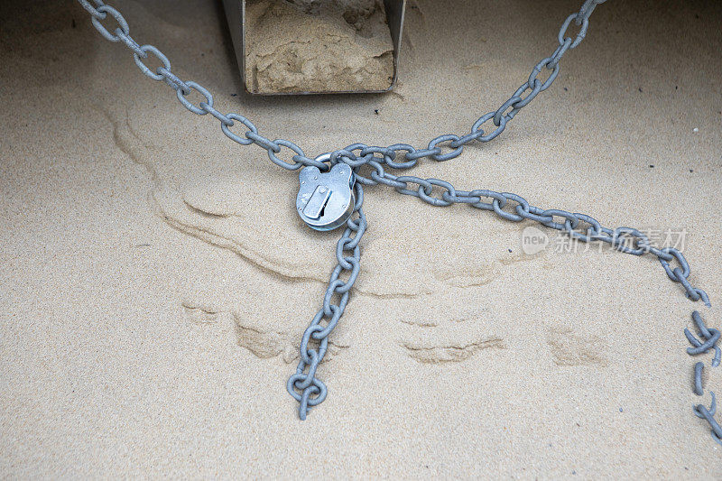 沙子上的挂锁和链条