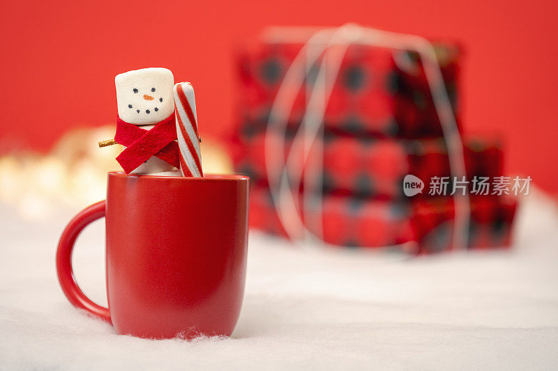 棉花糖雪人在热巧克力杯与薄荷棒与礼物