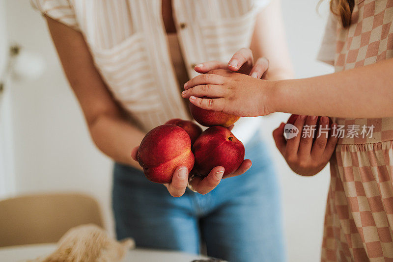 认不出来的母女拿着几颗油桃