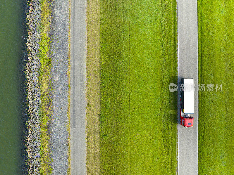 有拖车的卡车行驶在乡村道路上