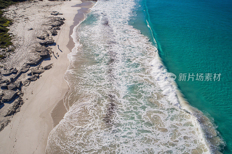 海滨鸟瞰图，沙滩和海水蓝色的海洋，人们在海滩上散步