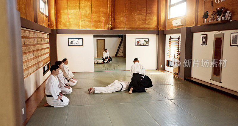 学生，合气道老师或教日本武术在道场练习，身体运动或自卫。格斗示范，黑带格斗班的一群人或训练锻炼
