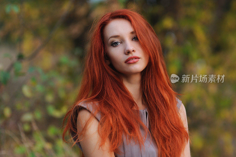 户外肖像美丽的年轻女子与红头发