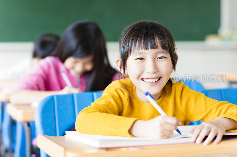 快乐的小女孩学生在教室里学习