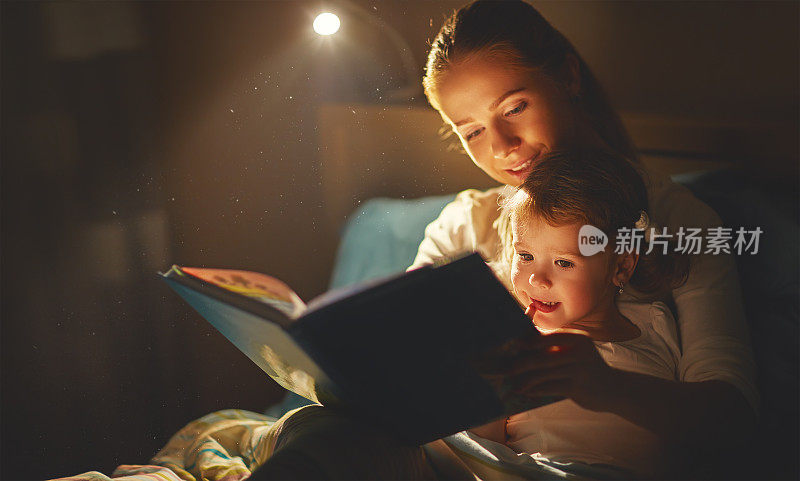 妈妈和小女孩在床上看书