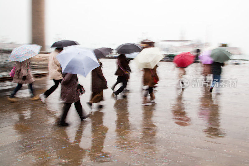 人们撑着雨伞在雨中行走