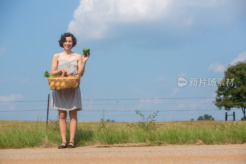 拿着一篮蔬菜的年轻女子