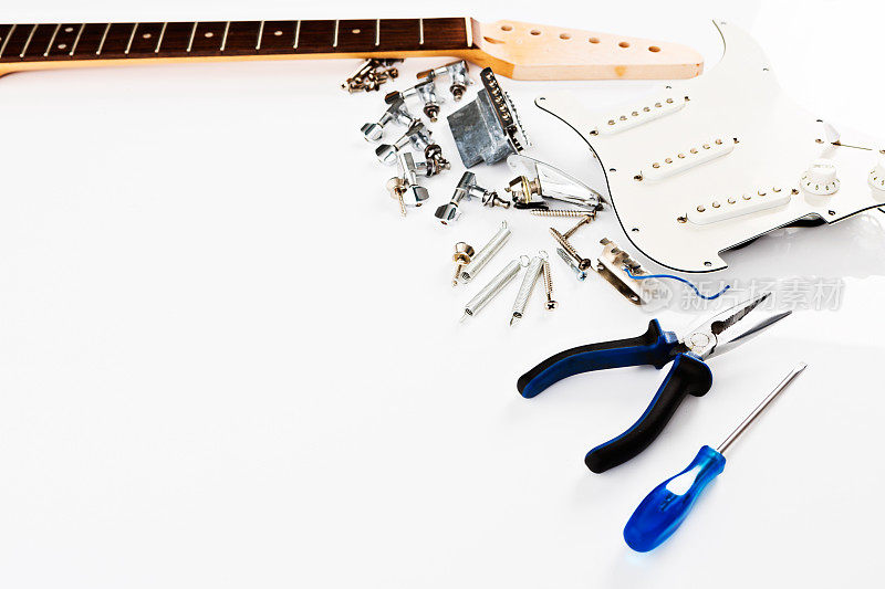 电吉他的零件和等待组装的工具排成一排