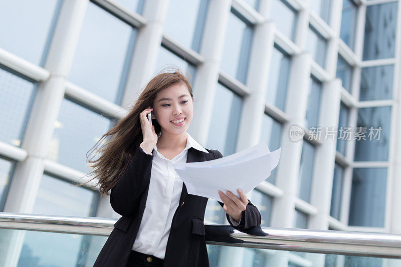 亚洲成功的女商人分析业务文件和通话