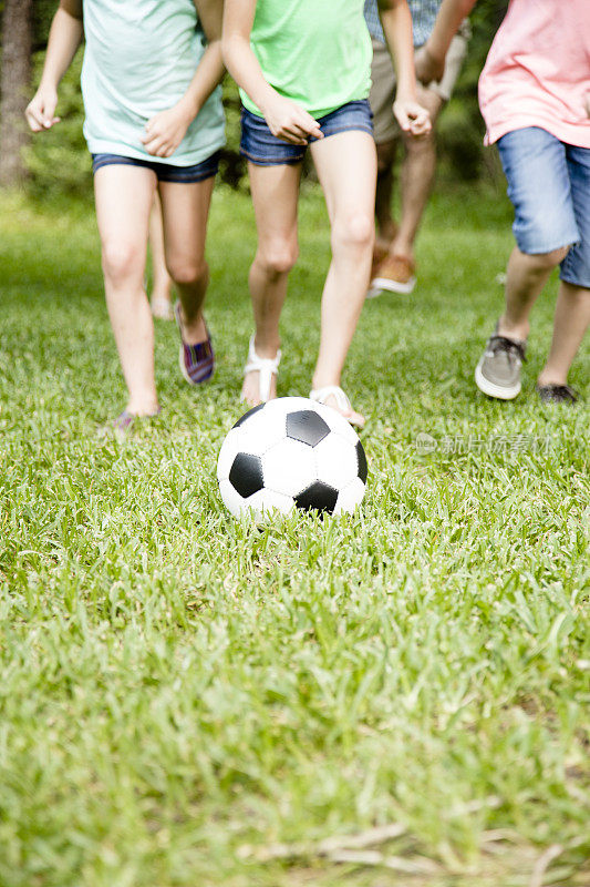 春天一家人在户外，夏天一起踢足球。公园,院子里。