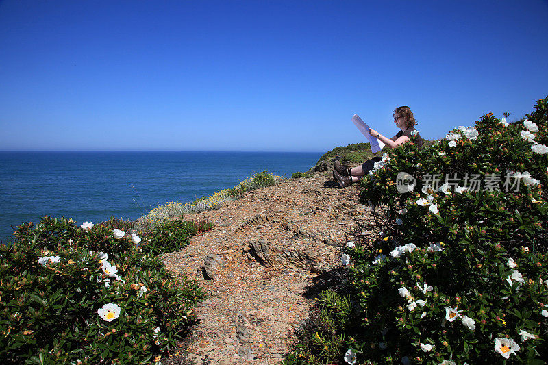 年轻女子在看悬崖上的地图