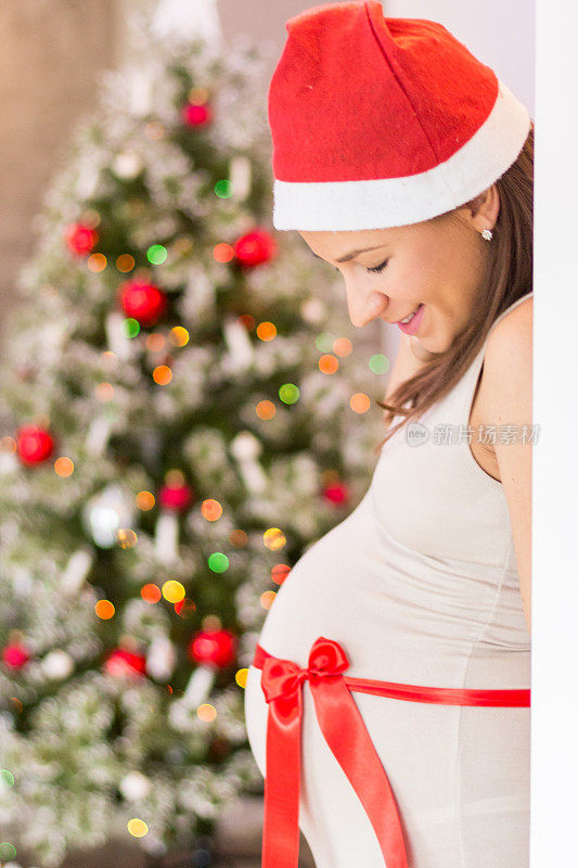 孕妇戴圣诞帽，肚子作为礼物送礼物