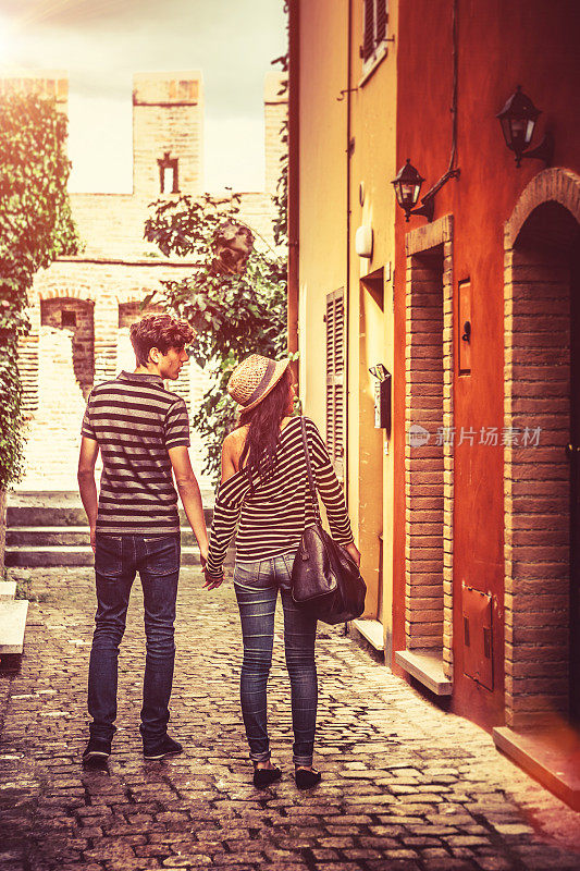 一对青少年情侣参观意大利的一个古城