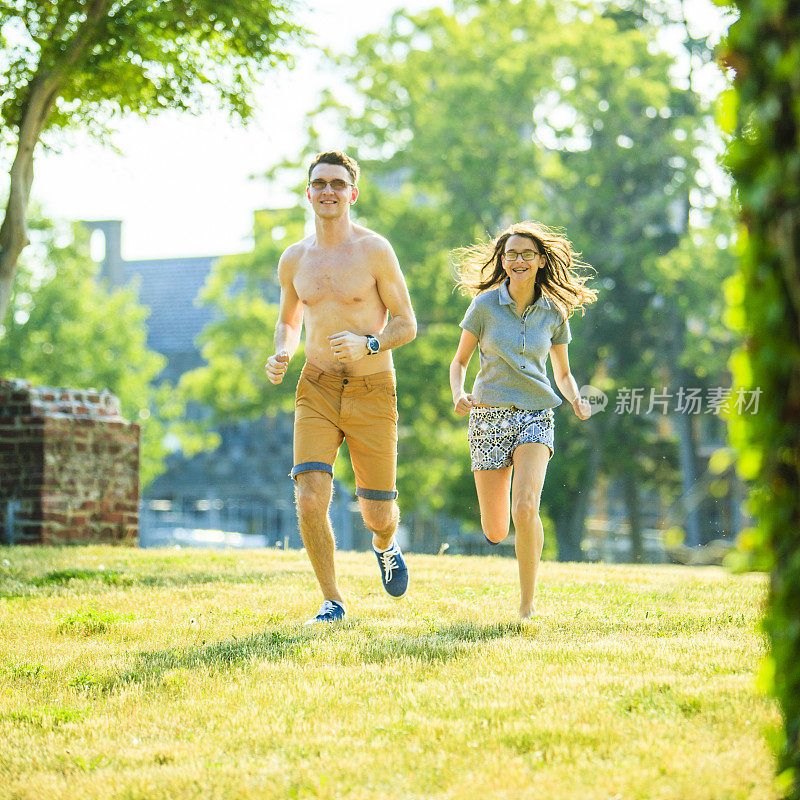 年轻的运动男子和少女在公园里跑步