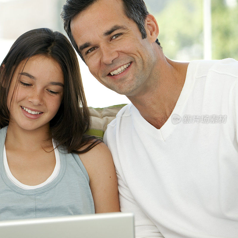 父亲和女儿使用笔记本电脑