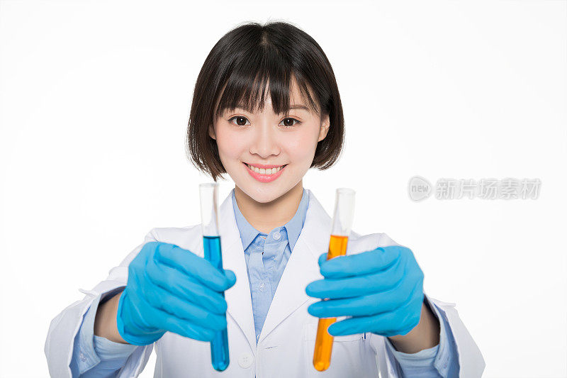 年轻的女性研究员在实验室里拿着两根试管