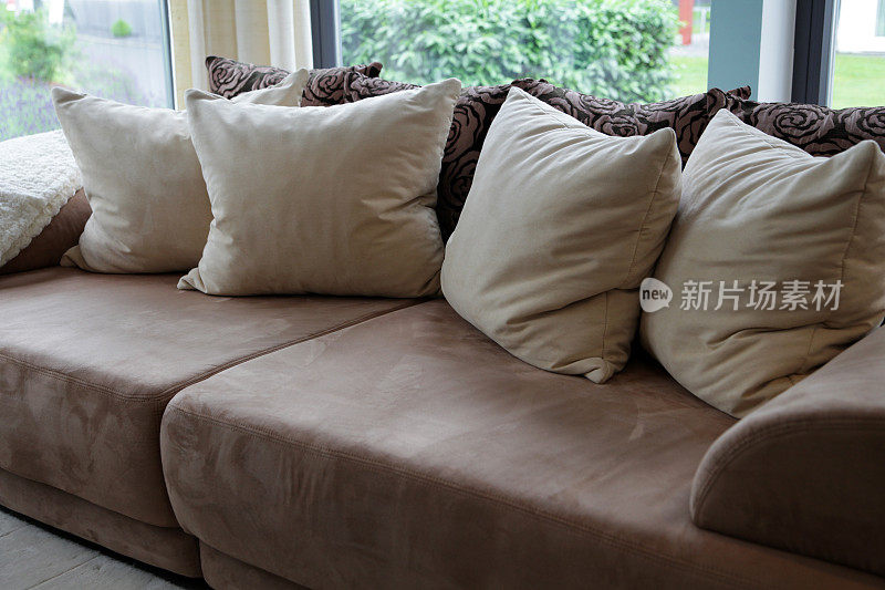 棕色软垫沙发和米色枕头