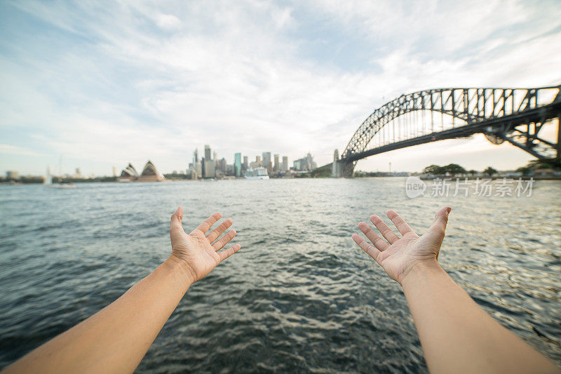 一名女子的双臂伸向澳大利亚悉尼的天际