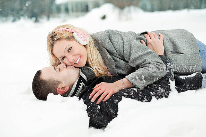 一对年轻夫妇在雪中拥抱