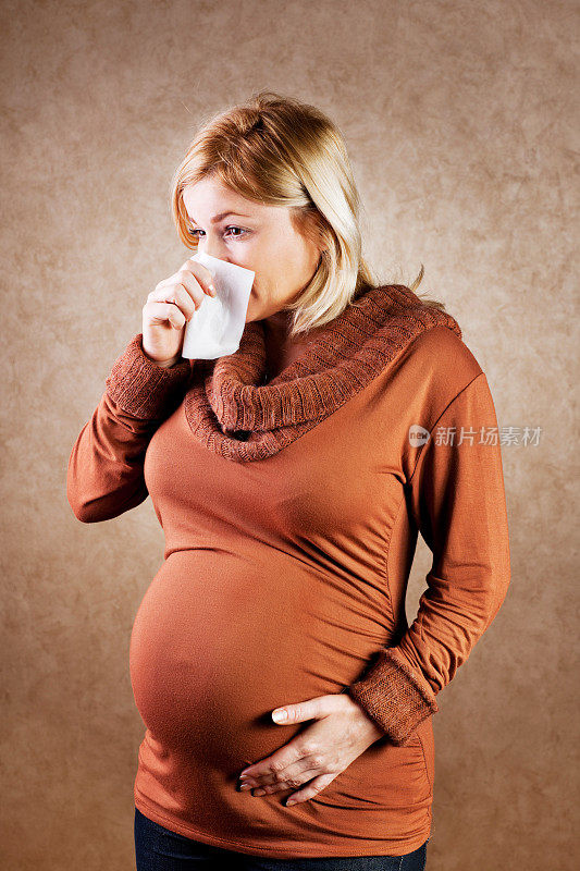 年轻孕妇在擤鼻涕。
