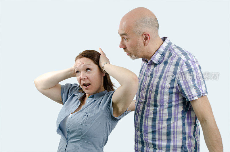 女人在生闷气，手捂着耳朵，男人试图跟她说话