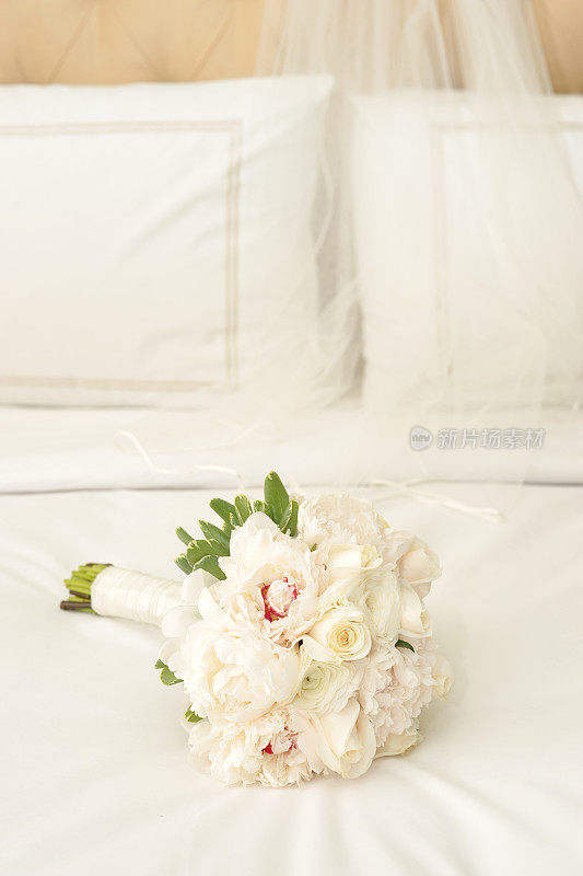 白色床单上的白色新娘花束