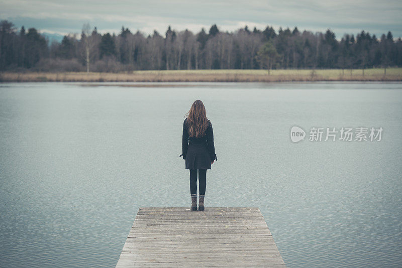 一个年轻女子在奥地利湖边的码头上