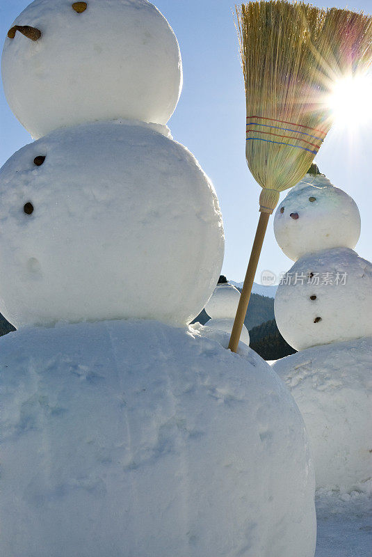 雪人军队-雪人戴着帽子和扫帚在太阳