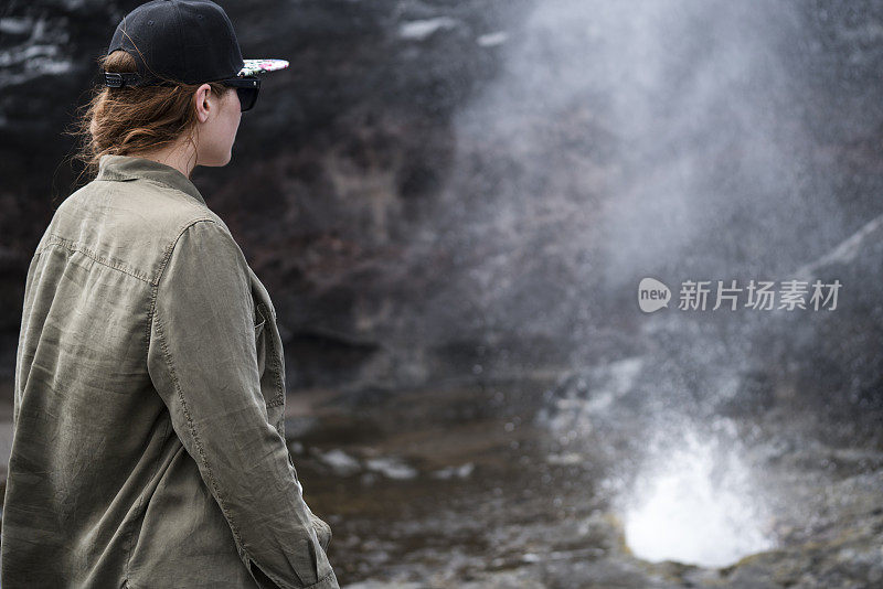 站在毛伊岛喷水孔后面的女人