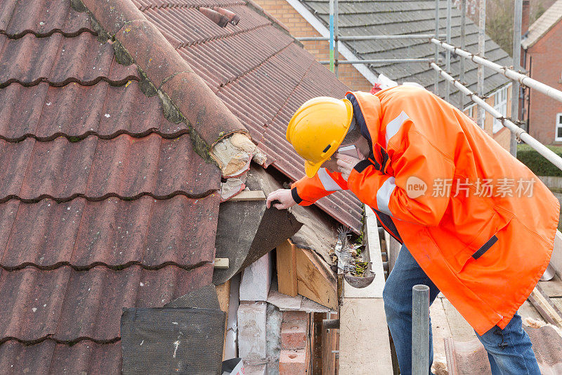 男性建筑测量师在屋顶上使用移动电话